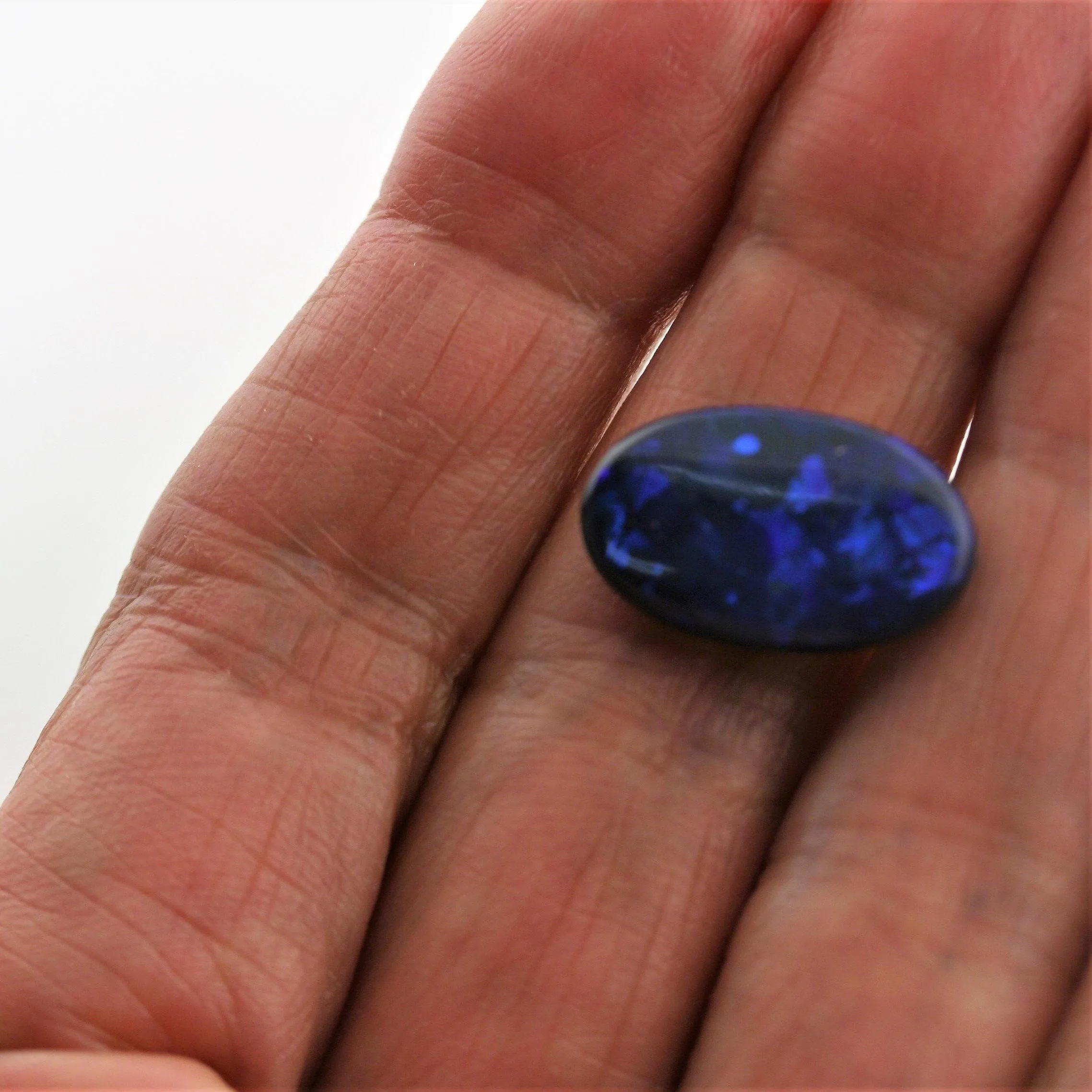 5.44 carat Black Opal Oval Flat Cabochon Blue Play of color